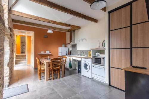 une cuisine avec une table et une salle à manger dans l'établissement Le Pamparou, coquette maison au calme, à Albussac
