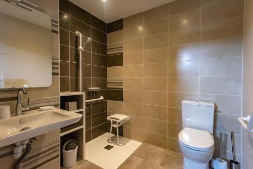 a bathroom with a toilet and a sink and a mirror at Le Pamparou, coquette maison au calme in Albussac