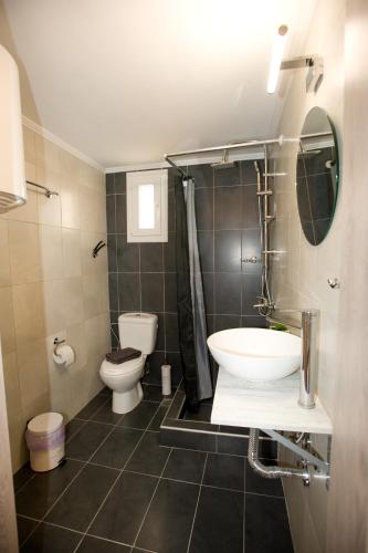 a bathroom with a sink and a toilet at Sea Gem Apartment 1 in Neoi Epivates