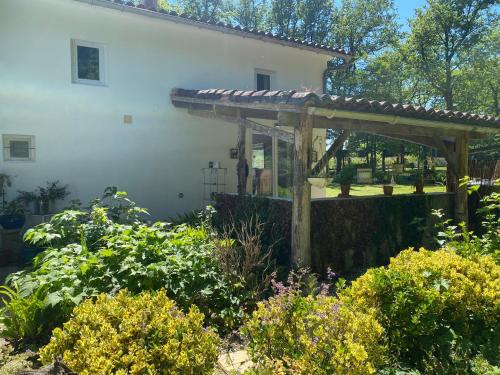 a garden in front of a house with a wooden pergola at Gite Les Justices in Édon