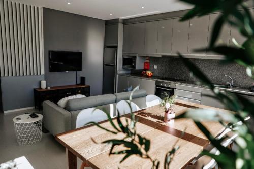 a kitchen and living room with a table and a couch at Rest House - Vila do Conde in Vila do Conde