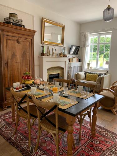 a living room with a table and a fireplace at La Grenouillère - Chambre d'hôtes de charme in Ballan-Miré