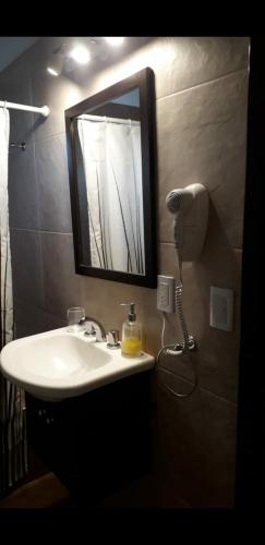 a bathroom with a sink and a mirror on the wall at Cabañas Ayres de Sierra in Los Reartes
