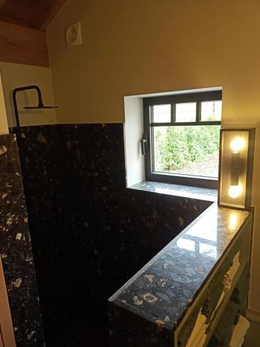 a bathroom with a window and a counter top at Mademoiselle Nineth met sauna in De Panne