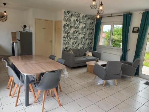 une cuisine et un salon avec une table et des chaises dans l'établissement Gîte Au coeur de la Baie, à Arrest