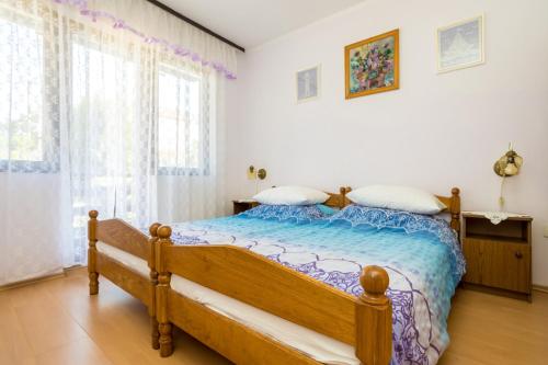 a bedroom with a wooden bed in a room at Apartments Filosevic by El-Pi Tours in Njivice