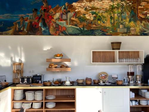 een keuken met een groot schilderij aan de muur bij Hôtel Christina Lourdes in Lourdes