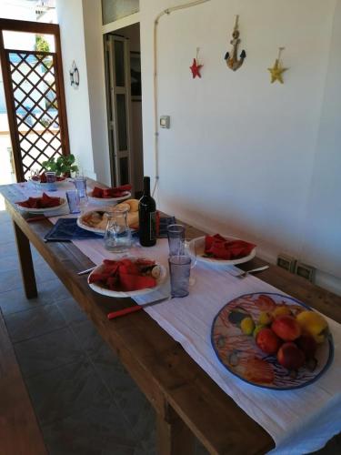 a wooden table with plates of fruit on it at Appartamento Meduse in Cala Gonone