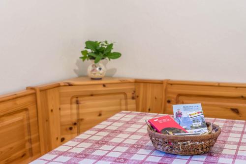 a table with a basket of books on a table at Sallrain Hof Monolokal 4 in Collalbo