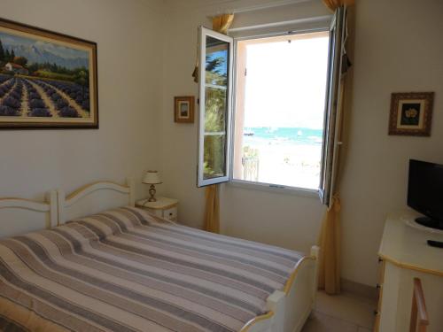 une chambre avec un lit et une grande fenêtre dans l'établissement Villa Playa del Sol - B1e1, à Saint-Tropez