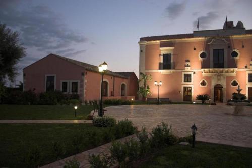 ein großes Gebäude mit einem Innenhof davor in der Unterkunft Hotel Lady Lusya in Syrakus