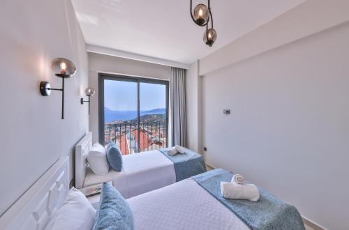 a bedroom with two beds and a large window at Mare Vista Apart in Kaş
