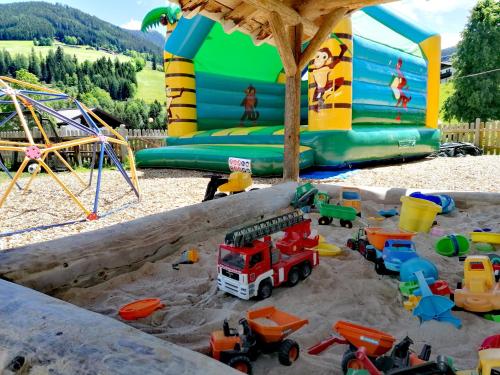 un grupo de juguetes en la arena en un parque infantil en FORSTAUERWiRT Hotel & Restaurant, en Forstau