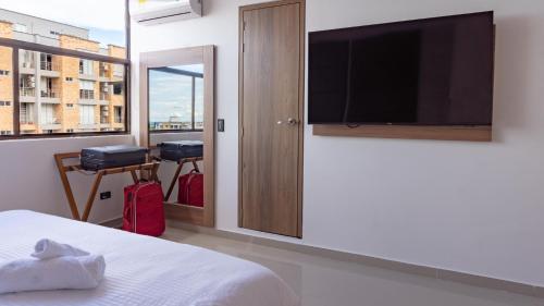 1 dormitorio con 1 cama y TV de pantalla plana en Primavera Plus en Villavicencio