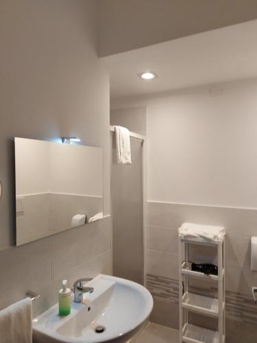 Baño blanco con lavabo y espejo en ROOM DEL PARCO, en Reggio Emilia