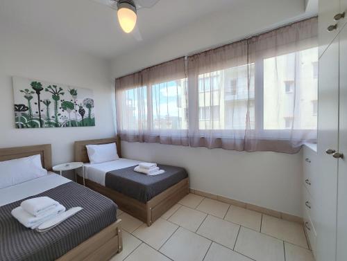 1 dormitorio con 2 camas y ventana en Niovis B1 by Verde Apartments, en Atenas