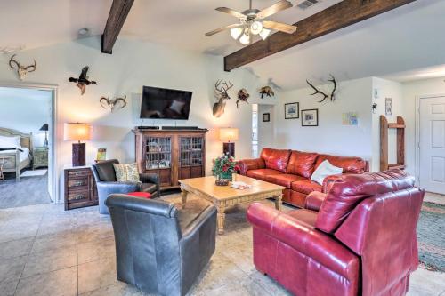 a living room with leather furniture and a ceiling fan at Charming Cameron Farm Retreat about 41 Mi to TAMU in Cameron