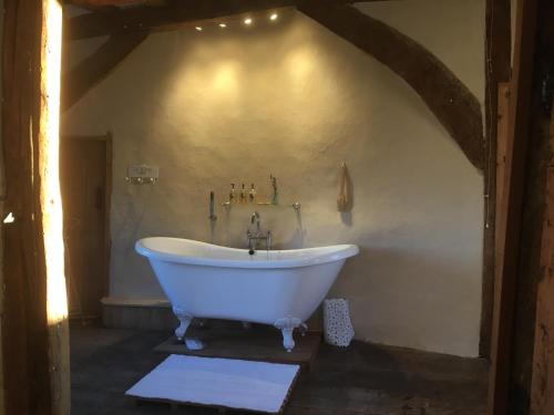 uma casa de banho com uma banheira branca num quarto em Valley Farmhouse B&B em Southwold