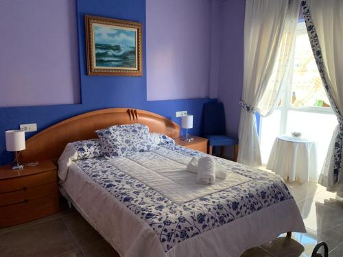 1 dormitorio con 1 cama con pared azul en Nerjamedina, en Nerja