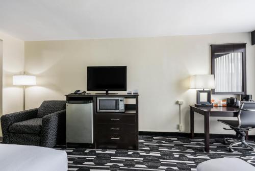 a hotel room with a tv and a couch and a chair at Bricktown Hotel & Extended Stay in Oklahoma City