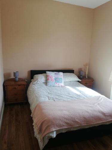 sypialnia z łóżkiem z 2 komodami i poduszką w obiekcie Rossport bungalow with an Atlantic view w mieście Ballina