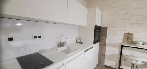 a white kitchen with a sink and a counter at Sleep and drive Suites in Sarajevo