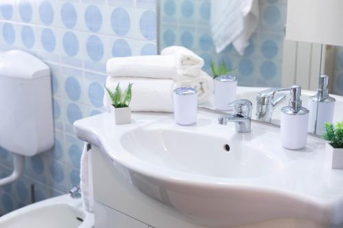 un baño con lavabo con toallas y plantas. en H11 ATTICO AL MARE - Santo Stefano al Mare - Grande Terrazzo, en Santo Stefano al Mare
