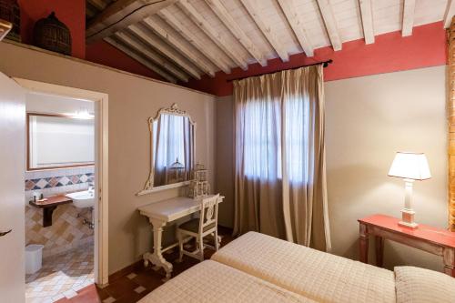 a bedroom with a bed and a sink and a mirror at Fattoria San Lorenzo in Grosseto