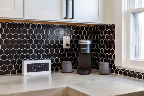 a kitchen with a counter with a coffee box on it at ModernTropic 2bd/1ba Near Beach w/ fence yard/deck in Lake Worth