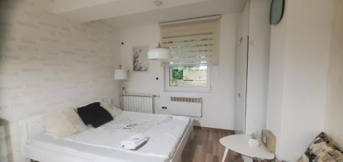Habitación blanca con cama y mesa en Sleep and drive Suites, en Sarajevo