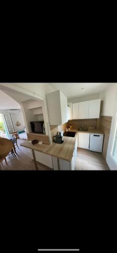 une cuisine avec des armoires blanches et une table dans une pièce dans l'établissement Le Gabian, duplex proche plage et centre, à Sanary-sur-Mer