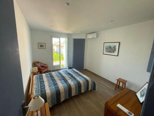 een slaapkamer met een bed en een raam bij Le Gabian, duplex proche plage et centre in Sanary-sur-Mer