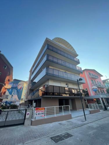 a tall building on a street in a city at Woody Green Charming Apartments - Agenzia Cocal in Caorle
