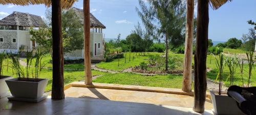 een open veranda met uitzicht op een tuin bij Amani Villas Nature Retreat in Michamvi