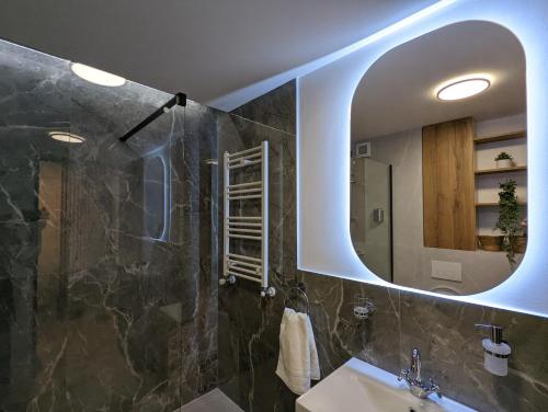 a bathroom with a sink and a mirror at [VerdeS] - Joyride Exclusive Apartment in Oradea