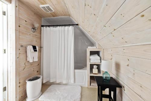 a bathroom with a white shower curtain and a table at Noble House Inn in Bridgton
