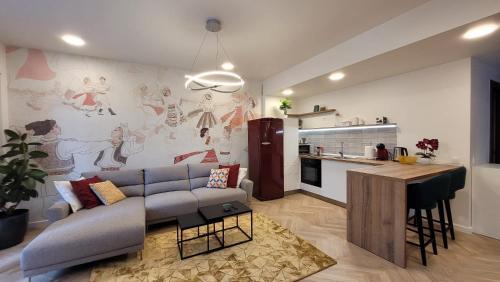 a living room with a couch and a kitchen at [VerdeS] - Joyride Exclusive Apartment in Oradea