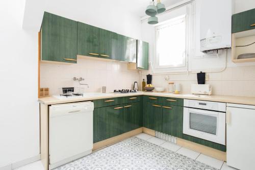 una cocina con armarios verdes y electrodomésticos blancos en Coachella Vintage Chic in the Heart of St Charles Biarritz, en Biarritz