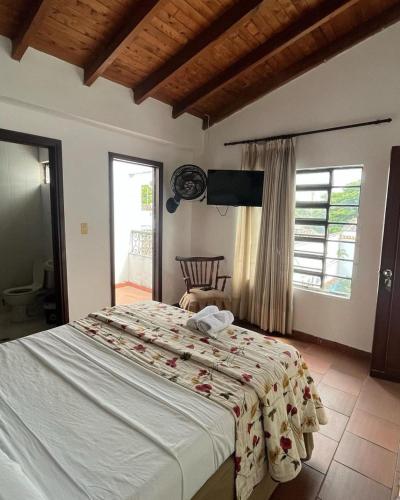 a bedroom with a large bed and a large window at Hotel ilama in Buga