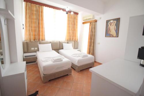 a living room with two beds and a couch at Oskar Hotel in Sarandë