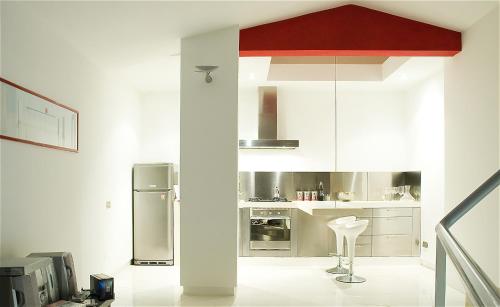 uma cozinha com armários brancos e um frigorífico de prata em Vatican Modern Designer Loft em Roma