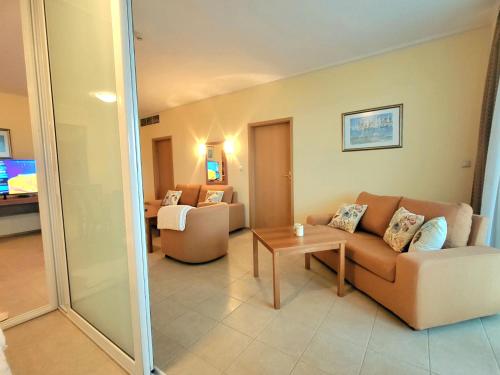 a living room with a couch and a table at "Красавиците тъмнокоси" Sunset Resort Pomorie in Pomorie