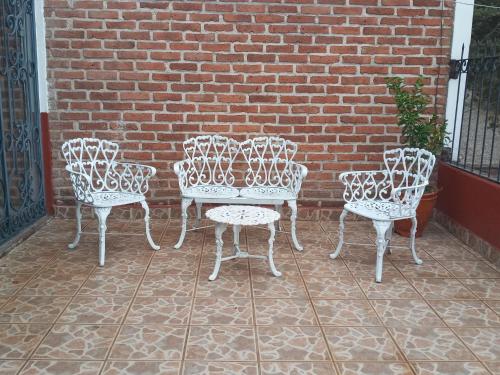 a group of four chairs and a table in front of a brick wall at Casa Tapalpa in Tapalpa