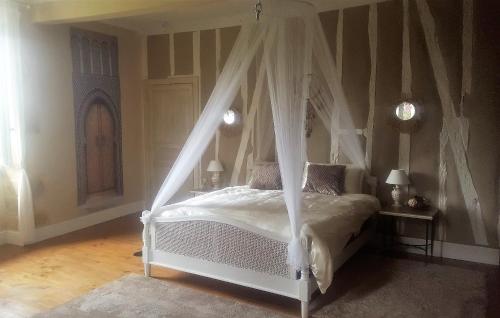 sypialnia z białym łóżkiem z baldachimem w obiekcie Maison du 18é de charme au calme w mieście Idrac-Respailles