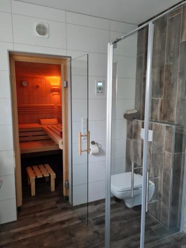 een badkamer met een douche, een toilet en een bad bij Wohnen2a in Harsewinkel
