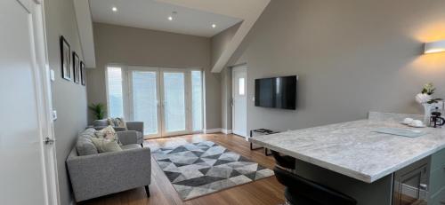 a living room with a table and a couch and a television at Stable Court Apartments in Antrim