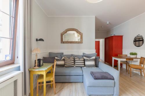 a living room with a blue couch and a table at Apartament Wigilijna Starówka in Elblag