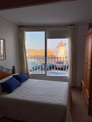 a bedroom with a bed and a large window at Apartamentos Sol y Lodo in Lo Pagán