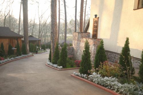 a garden in front of a house with trees and flowers at Kolyba House in Kyiv