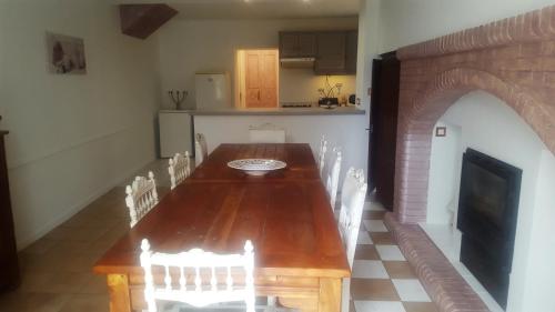 - une table et des chaises en bois dans la cuisine dans l'établissement Maison du 18é de charme au calme, à Idrac-Respailles